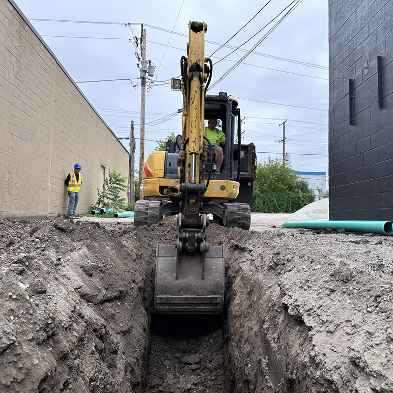 Excavator working in a trench at a construction site